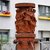 Rotes Brunnenbecken mit Reliefdarstellung einer sitzenden Frau, die ein Kind auf dem Schoß hält und ein weiteres Kind an der Hand führt, umgeben von pflanzlichen Ornamenten.