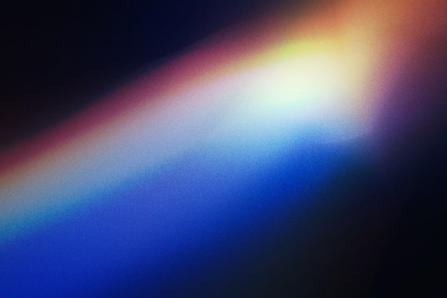Lichtstreifen oder Regenbogeneffekt auf dunklem Hintergrund, der durch Lichtbrechung, etwa an einer CD oder einem Prisma, entsteht.