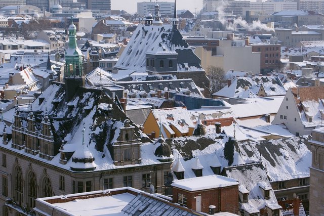 Schneebedeckte Dächer Halles mit Stadthaus