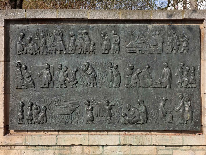 Steinrelief mit mehreren erhabenen Szenen, die Menschen bei verschiedenen Tätigkeiten zeigen: Bauern bei der Arbeit, Ernte, Tieren, die gezogen werden, sowie Handwerker und Alltagssituationen im antiken Stil.
